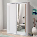 Sliding wardrobe door with mirror in a room with a sofa and decorative items.