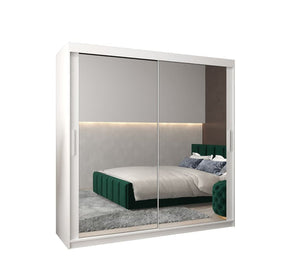 Sliding wardrobe with mirror doors showing a bedroom interior.