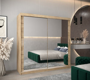 Modern bedroom with a large mirror wardrobe, green bed, and decorative elements.