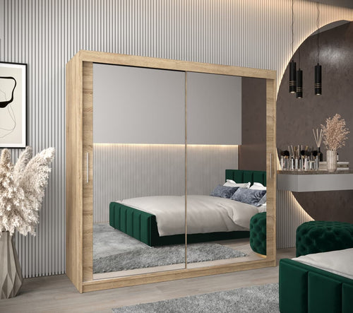 Modern bedroom with a large mirror wardrobe, green bed, and decorative elements.