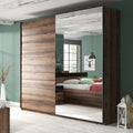 Wooden wardrobe with mirror doors in a bedroom setting