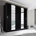 Modern black wardrobe with sliding doors in a stylish room.