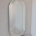 Octagonal mirror with decorative frame on a plain wall