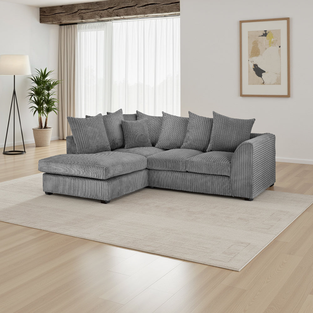 Gray sectional sofa in a living room with a large window and plant.