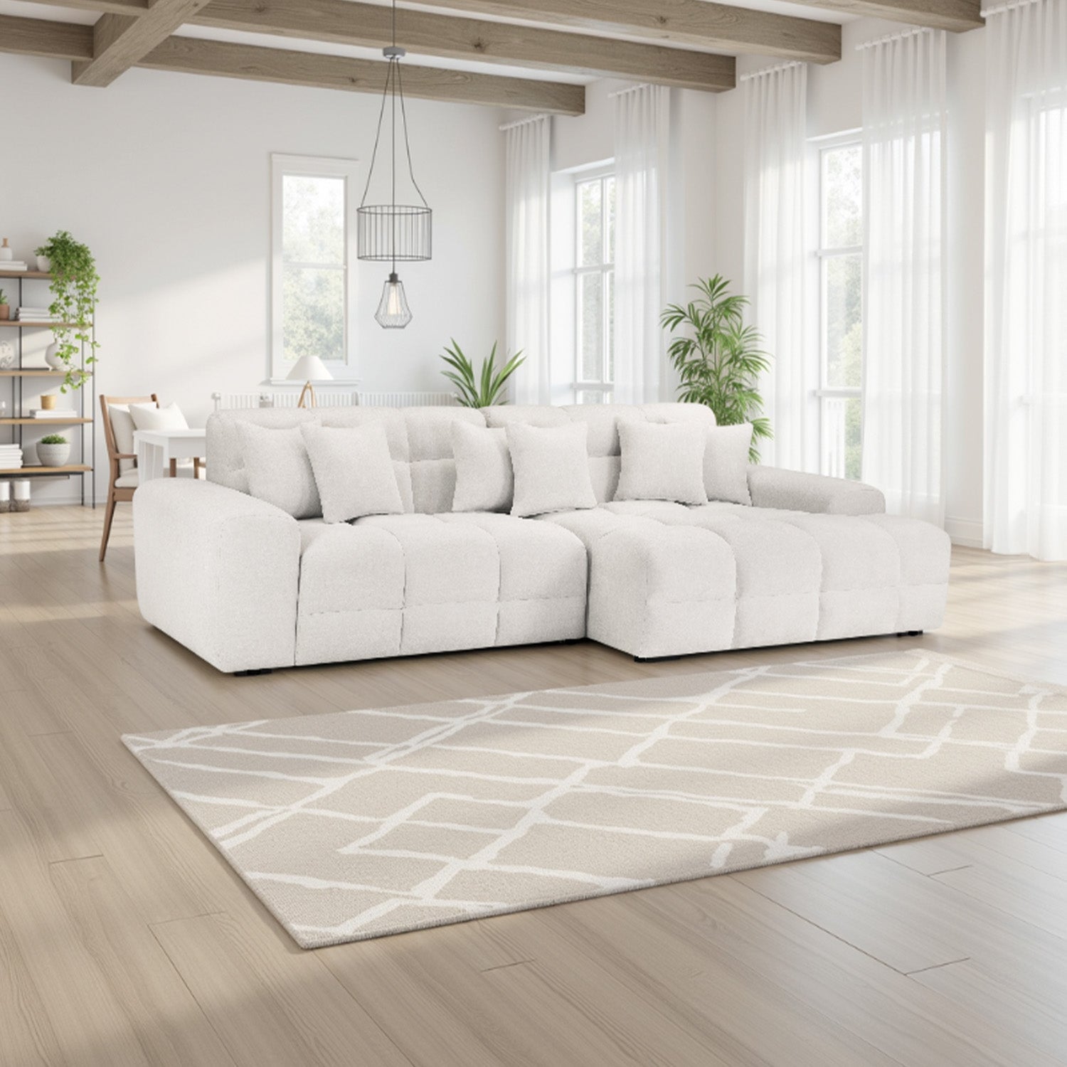 White sectional sofa in a modern living room with large windows and a patterned rug.