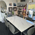 Dining room with a marble table and gray chairs in a home interior setting.