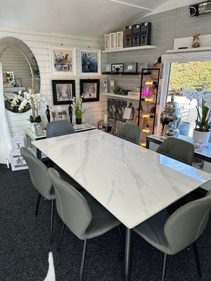 Dining room with a marble table and gray chairs in a home interior setting.