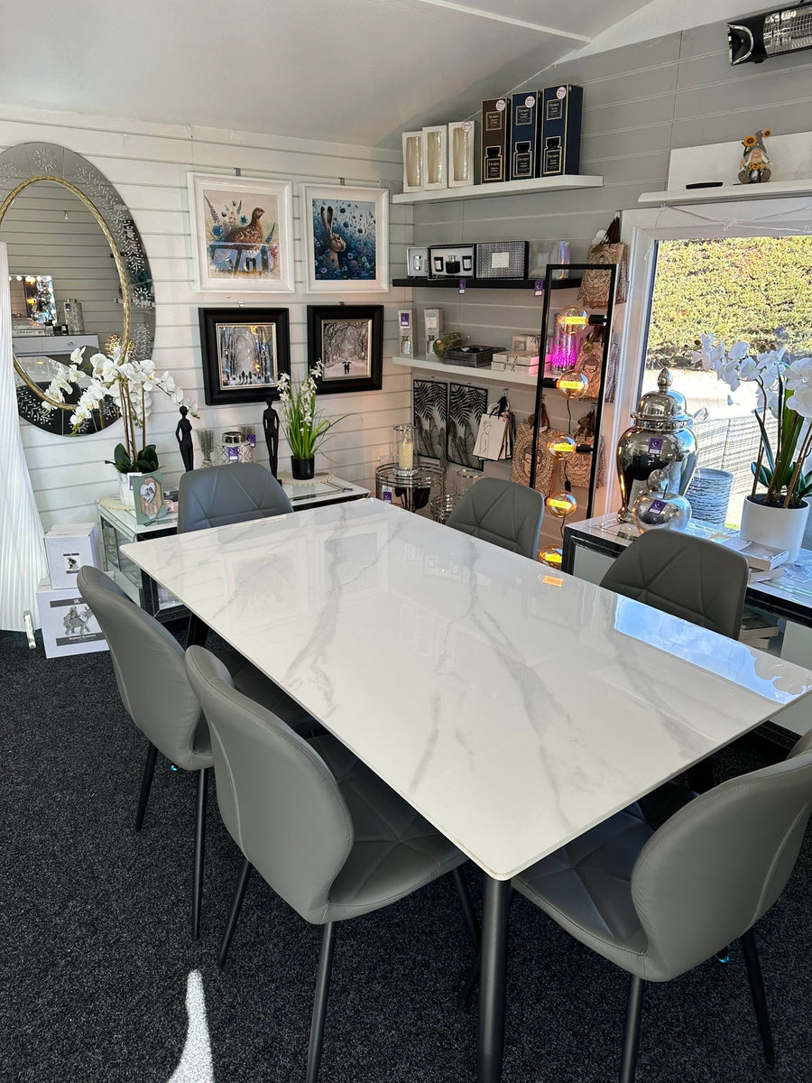 Dining room with a marble table and gray chairs in a home interior setting.