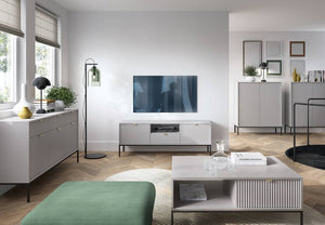Modern living room with a TV on a stand, coffee table, and decorative items.