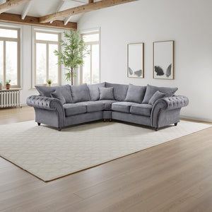 Gray sectional sofa in a bright living room with large windows and wooden beams.