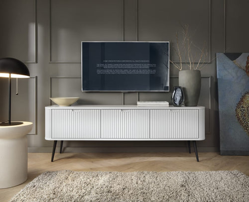 Modern living room with a white entertainment console, TV, and decorative items.