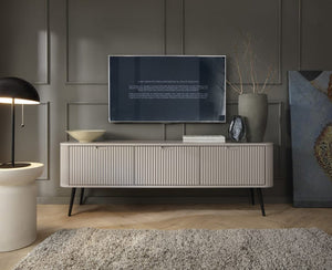 Modern living room with a television on a white console table, decorative items, and a dark wall.