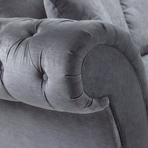 Close-up of a gray upholstered chair with tufted backrest