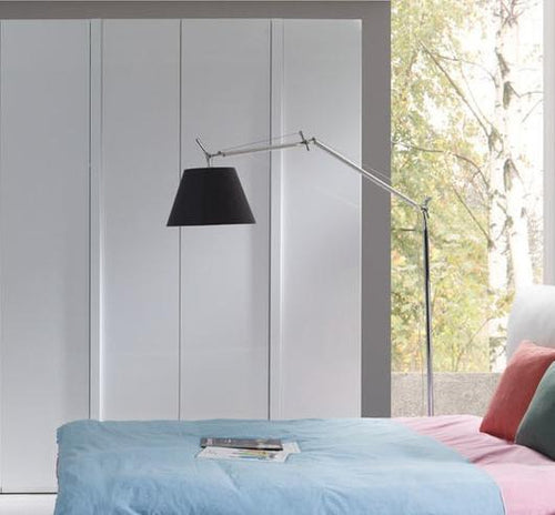 Modern bedroom with a bed, lamp, and window view
