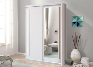 Sliding wardrobe door with mirror in a room with a sofa and decorative items.