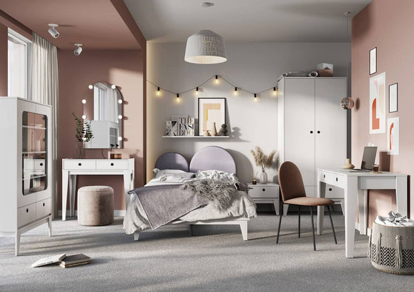 Modern bedroom with pink walls, gray headboard, and white furniture.