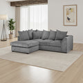 Gray sectional sofa in a living room with a large window and plant.