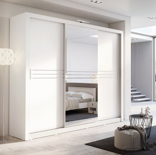 Modern white wardrobe with sliding doors in a bedroom setting