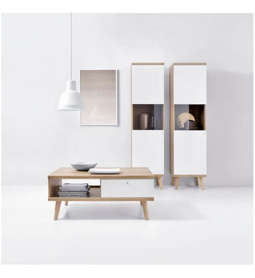 Modern interior with a wooden coffee table and white cabinets against a white wall.