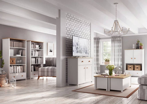 Modern living room with white furniture, bookshelves, and decor.