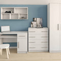 White office desk with chair, cabinet, and shelves against a blue wall.