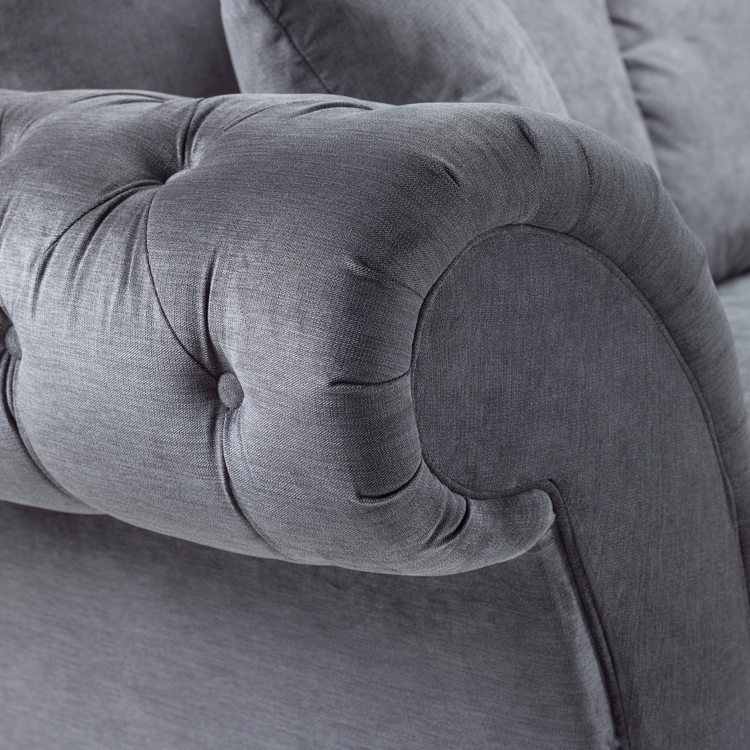 Close-up of a gray upholstered chair with tufted backrest