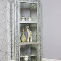 Decorative glass cabinet with embellished frame against a gray wall with geometric pattern.